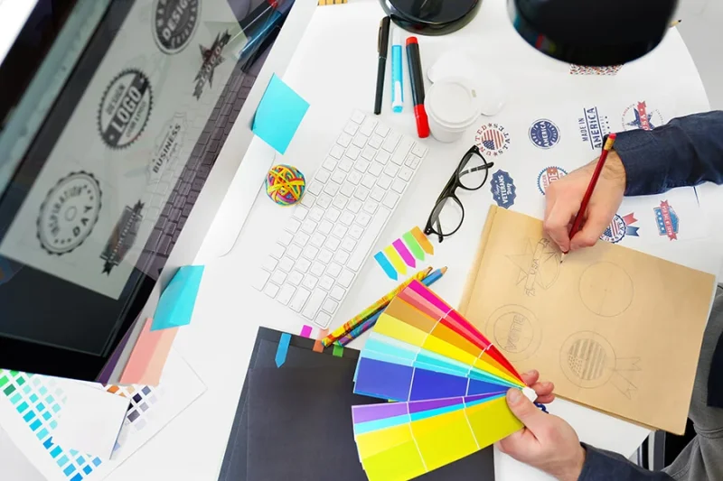 Logo sketch, colour swatch and computer screen